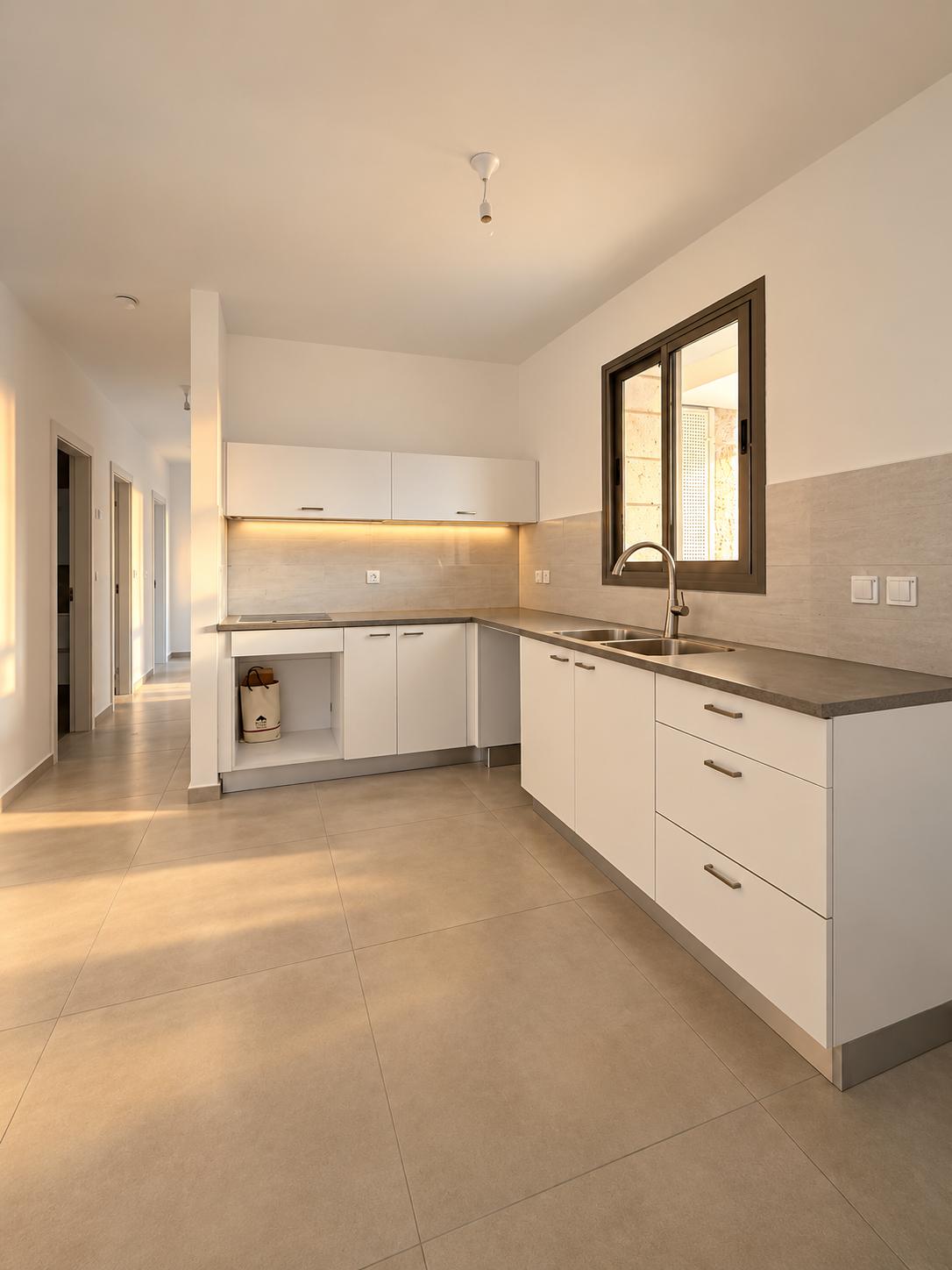 1002777834 Frankel apartment kitchen with white cabinets and open living space.