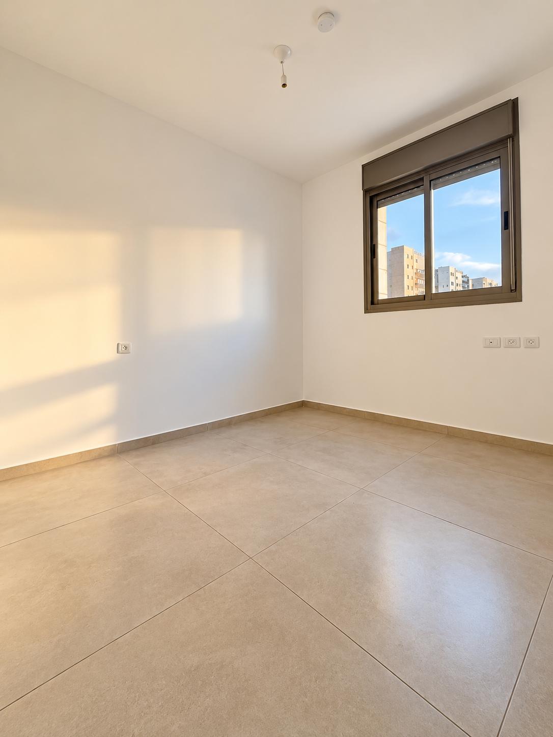 1002777835 Frankel apartment bedroom with a window and tiled floor.