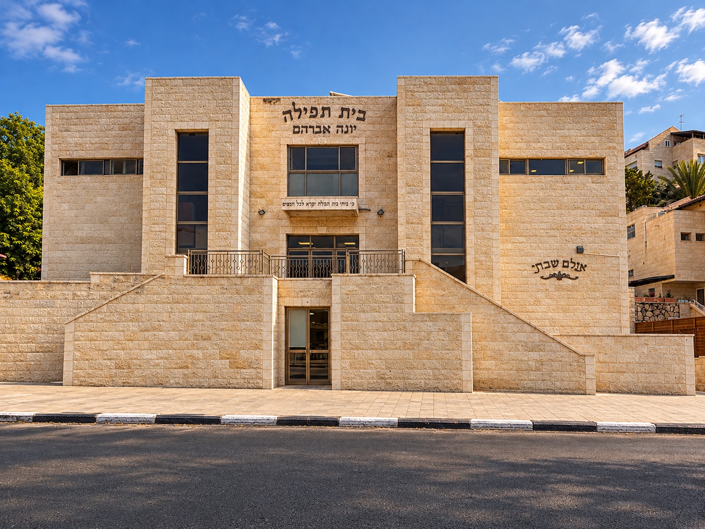 Exterior of Beis Tefillah Yonah Avraham, with stone facade and entrance steps.